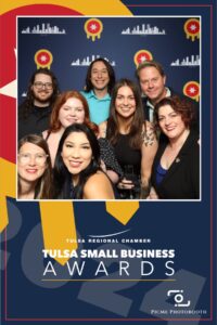 A group of nine people posed in front of a backdrop at the Tulsa Small Business Awards, organized by the Tulsa Regional Chamber.