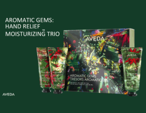 Aveda Aromatic Gems Hand Relief Moisturizing Trio set with three tubes and a decorative box on a dark green background.